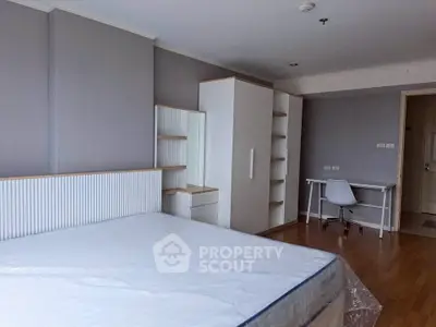 Spacious bedroom with modern furniture and study area, perfect for comfortable living.