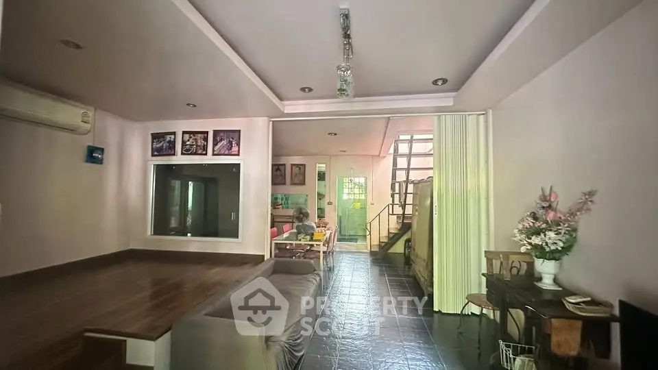 Spacious living room with modern decor and open layout, featuring a cozy seating area and stylish lighting.