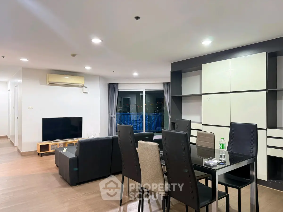 Spacious modern living room with dining area and city view, perfect for urban living.
