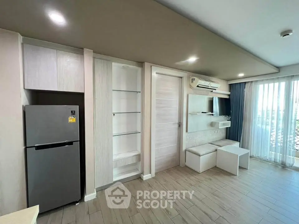 Modern living room with sleek design and natural light, featuring built-in storage and air conditioning.