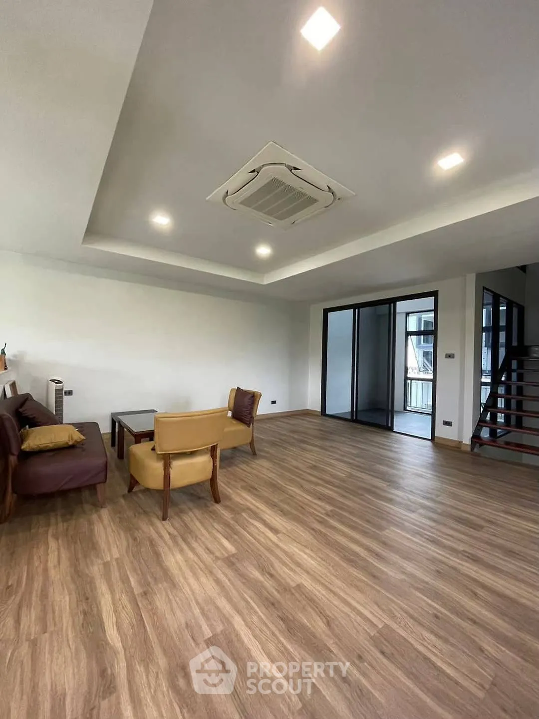 Spacious modern living room with wooden flooring and large windows