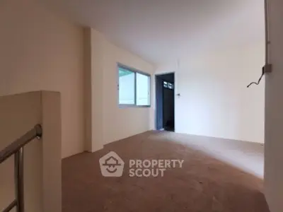 Spacious unfurnished room with large window and neutral tones, perfect for customization.