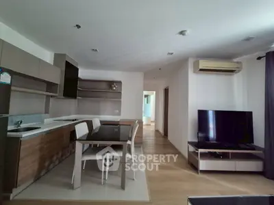 Modern open-layout kitchen and living area with sleek furniture and natural light.