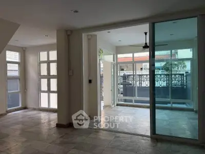 Spacious modern living area with large windows and sliding glass doors opening to a balcony.