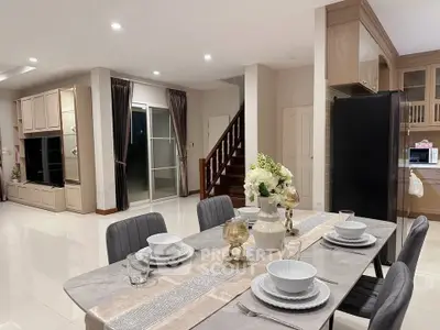 Spacious open-plan dining and living area with modern decor and elegant table setting.