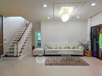 Luxurious living room with elegant staircase and modern chandelier