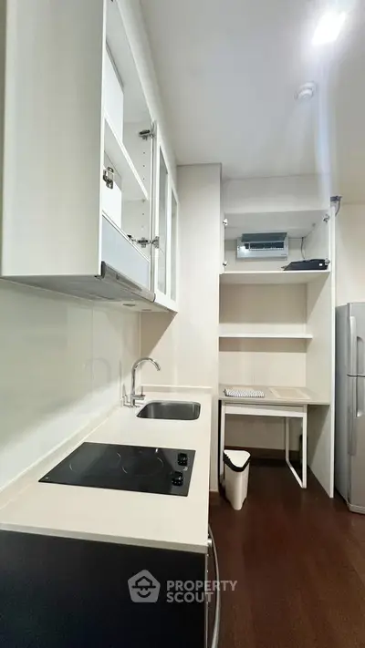 Modern kitchen with sleek design, featuring electric stove and ample storage space.