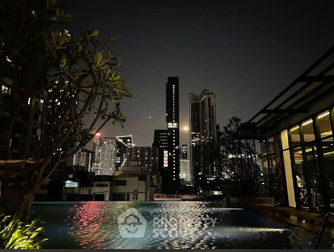 Stunning city skyline view from a rooftop pool at night, perfect for urban living.