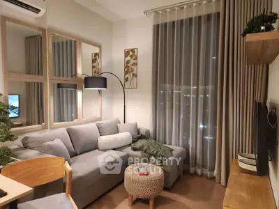 Cozy modern living room with stylish decor and large window view.