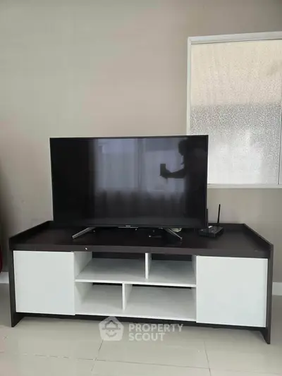 Modern living room with sleek TV stand and flat-screen TV, perfect for entertainment setup.