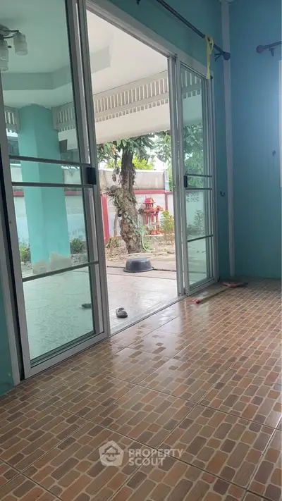 Spacious room with sliding glass doors opening to a serene garden view.