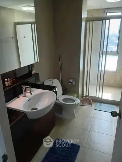 Modern bathroom with sleek fixtures and natural light, featuring a glass shower and stylish vanity.