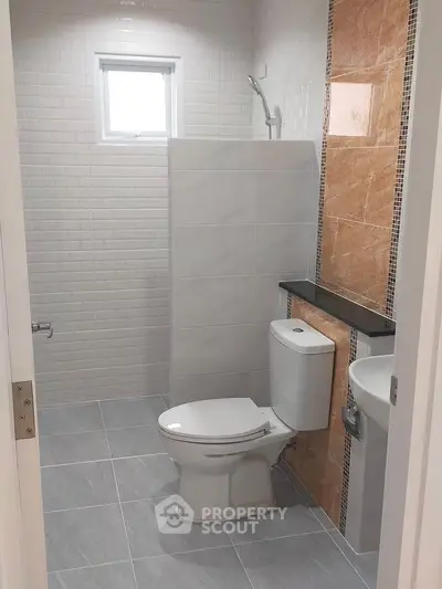 Modern bathroom with sleek design and neutral tones, featuring a compact layout and stylish fixtures.