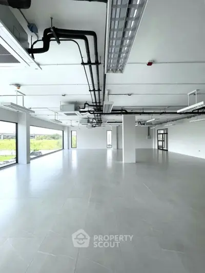 Spacious modern office space with large windows and sleek flooring