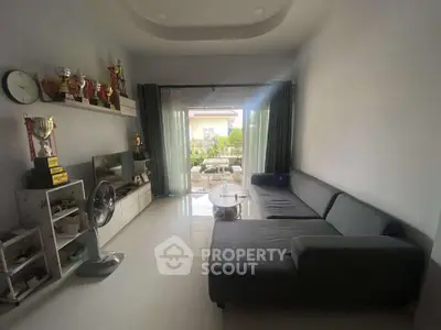 Spacious living room with modern decor and large windows opening to a balcony, perfect for relaxation.