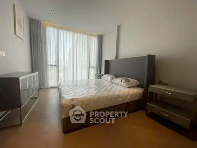 Spacious modern bedroom with large window and stylish furnishings