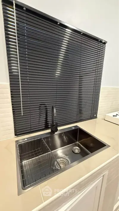 Modern kitchen sink with sleek black blinds and stylish faucet