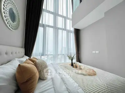 Luxurious bedroom with floor-to-ceiling windows and elegant decor in modern apartment.