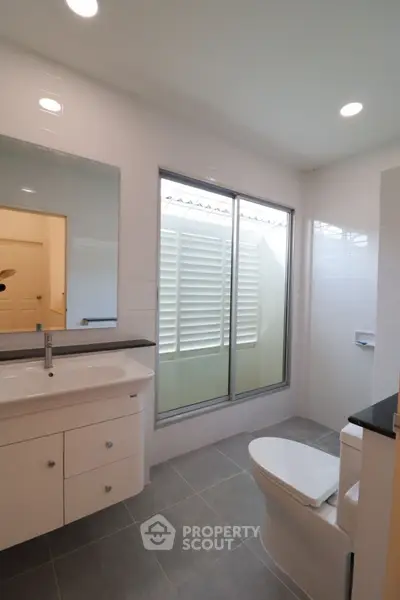 Modern bathroom with sleek fixtures and large window for natural light.