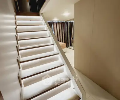 Modern interior with illuminated staircase and cozy bedroom area.