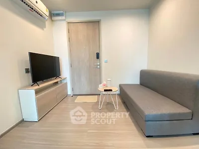 Modern living room with sleek furniture and minimalist design, featuring a comfortable sofa and flat-screen TV.