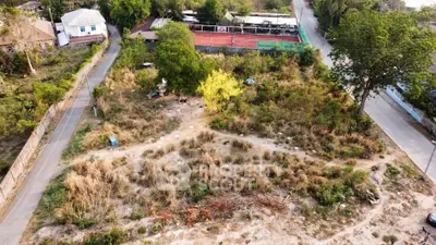 Vacant land plot with potential for development, surrounded by greenery and accessible roads.