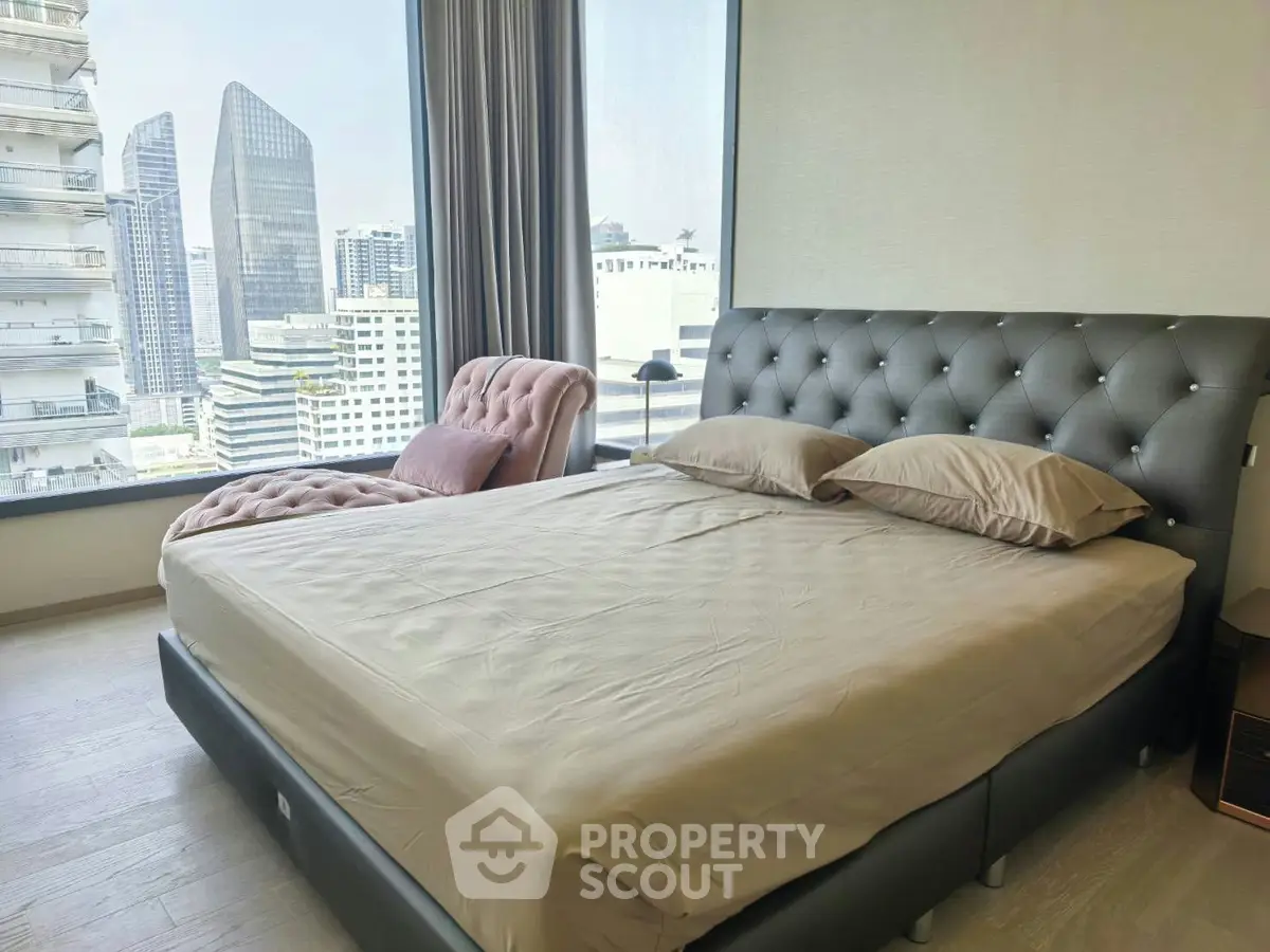 Luxurious bedroom with stunning city view and elegant furnishings in a high-rise apartment.