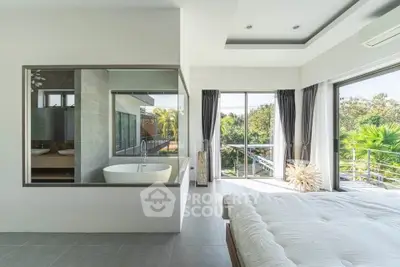 Luxurious bedroom with large windows and modern bathtub, offering serene garden views.