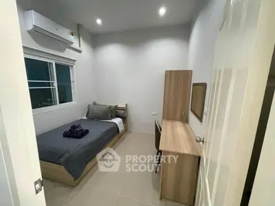Cozy modern bedroom with air conditioning and sleek furniture, perfect for a comfortable living experience.