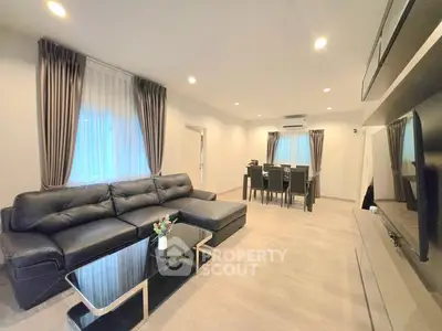 Spacious modern living room with elegant decor and dining area, perfect for family gatherings.