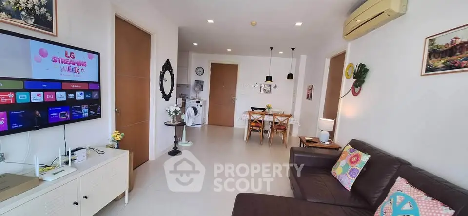 Modern living room with stylish decor, wall-mounted TV, and cozy seating area in a contemporary apartment.