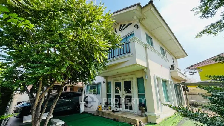 Charming two-story house with lush greenery and carport in a serene neighborhood.