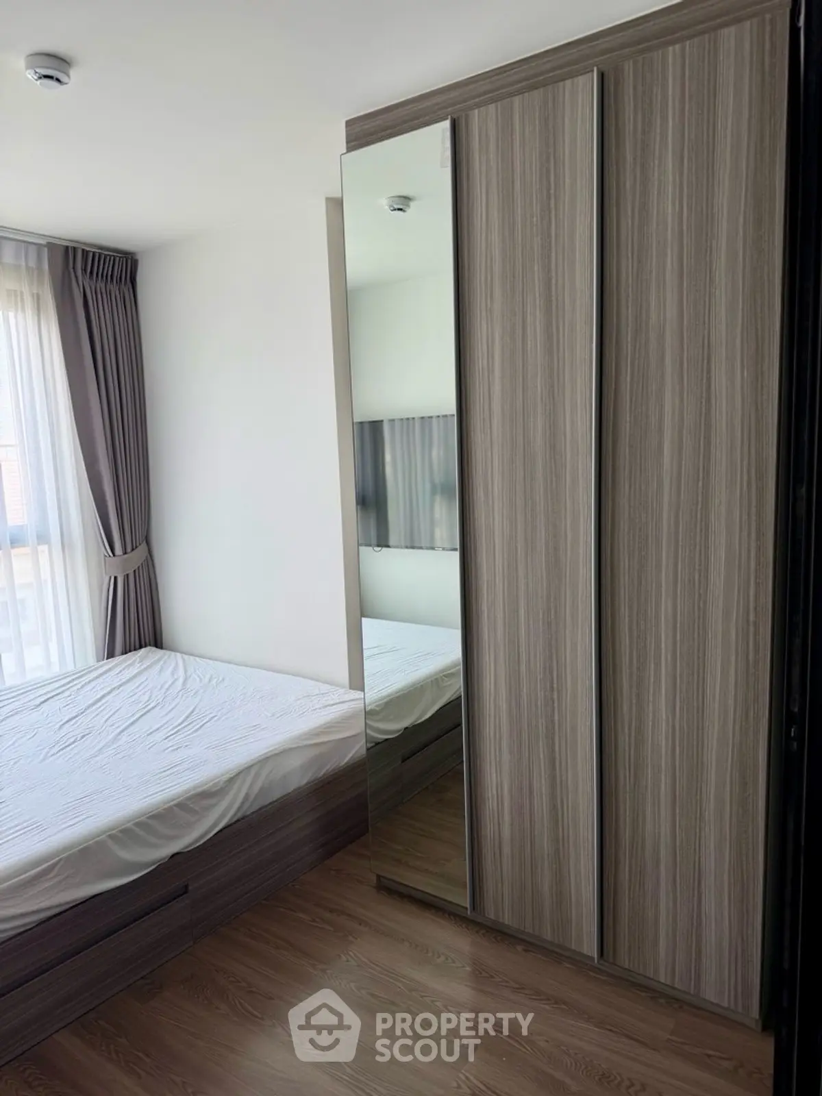 Modern bedroom with sleek wardrobe and large window for natural light