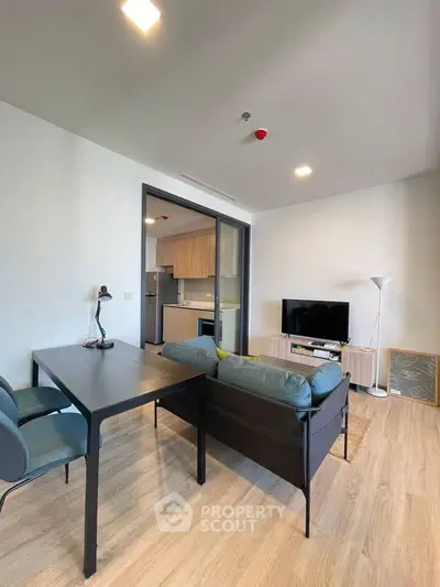 Modern living room with sleek furniture and open kitchen layout in a stylish apartment.