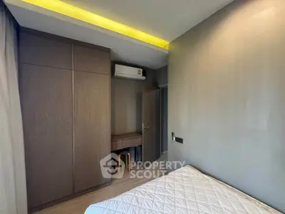 Modern bedroom with built-in wardrobe and air conditioning unit.