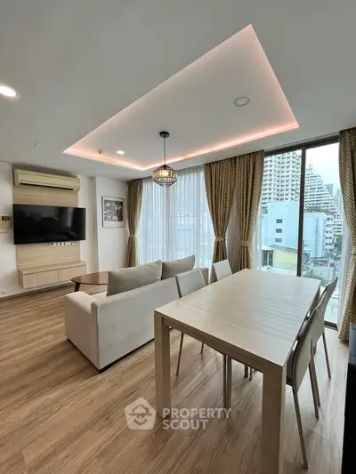 Modern living room with stylish decor and city view, featuring a cozy sofa and dining area.