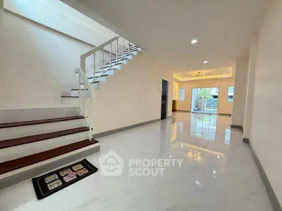 Spacious modern living room with elegant staircase and glossy flooring