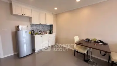 Charming kitchen with modern appliances and cozy dining area in a stylish apartment.