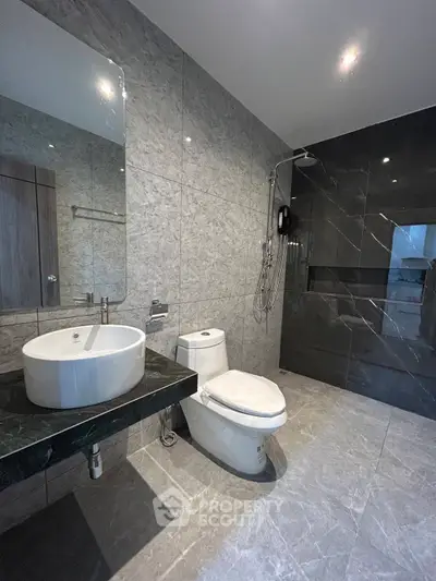 Luxurious modern bathroom with sleek marble tiles and elegant fixtures.