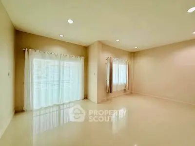 Spacious empty room with large windows and elegant curtains, perfect for customization.
