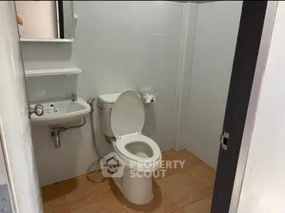 Compact bathroom with modern fixtures and tiled flooring, ideal for efficient space utilization.