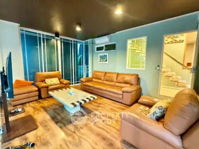 Spacious living room with modern leather sofas and wooden flooring