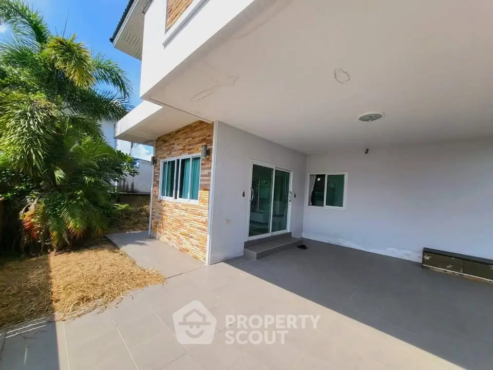 Spacious modern home exterior with patio and lush greenery, perfect for outdoor relaxation.