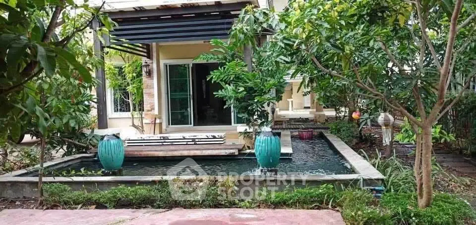 Charming garden view with serene pond and lush greenery in a modern home exterior.