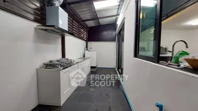 Modern kitchen with sleek cabinetry and washing machine in a well-lit space.