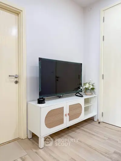 Modern living room with sleek TV stand and flat-screen TV, showcasing minimalist design and elegant decor.