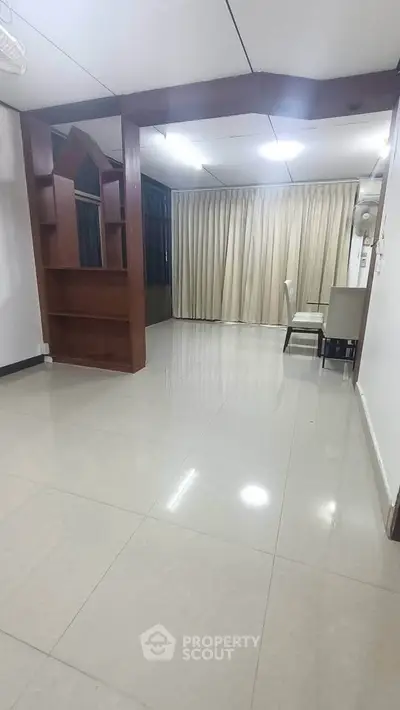 Spacious living room with elegant curtains and tiled flooring