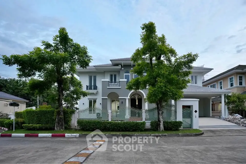Elegant two-story house with lush greenery and spacious driveway in a serene neighborhood.