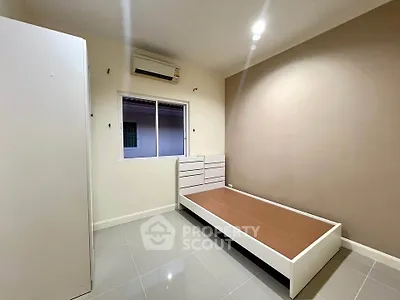 Minimalist bedroom with sleek flooring and modern air conditioning unit.