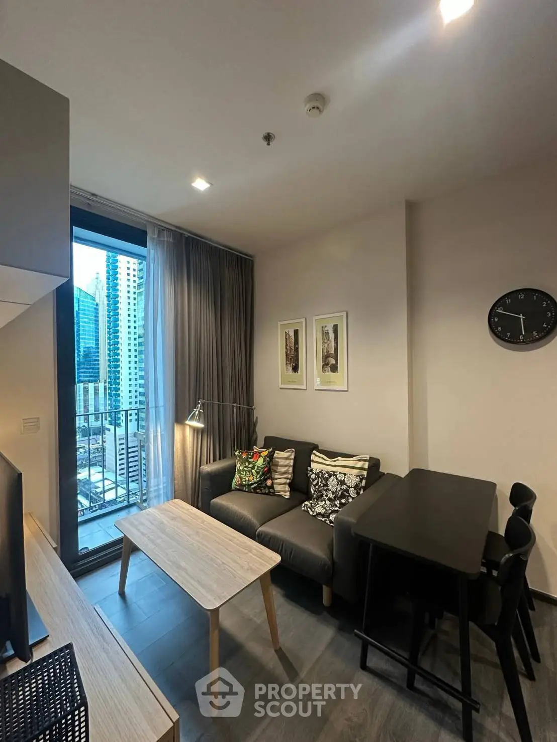 Modern living room with city view, stylish decor, and cozy seating area in urban apartment.